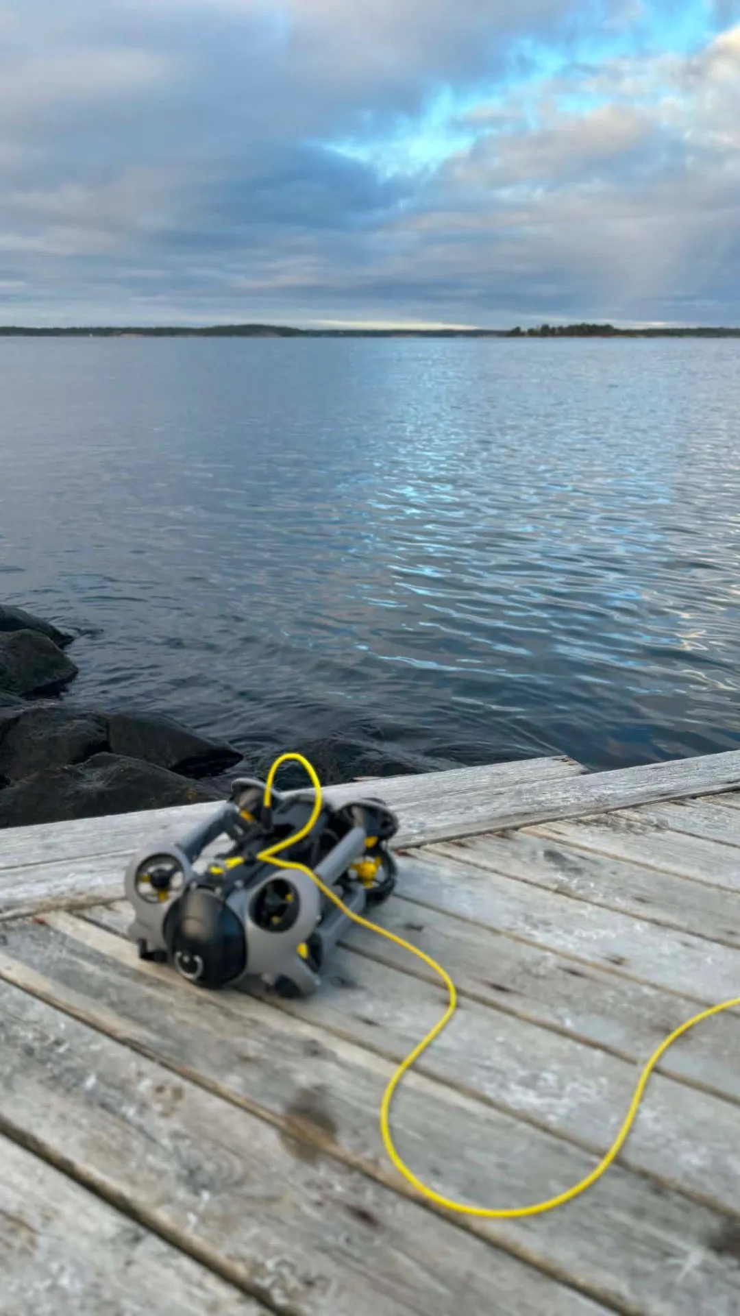 Undervattensdrönare med gul kabel på brygga inför inspektion